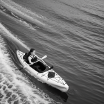 A black and white line art illustration of a kayak on a river, featuring clean outlines and blank spaces for coloring enthusiasts.
