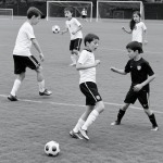 Black and white line art of kids playing soccer, featuring simple, clean outlines suitable for coloring, with a focus on uncolored, blank fill areas.